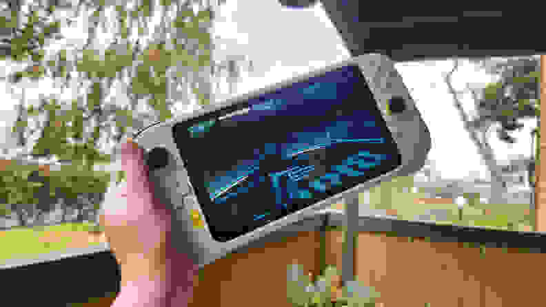 Someone holding a handheld gaming console showing a game.