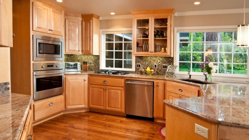 A modern kitchen with wood aesthetic and marble countertops.