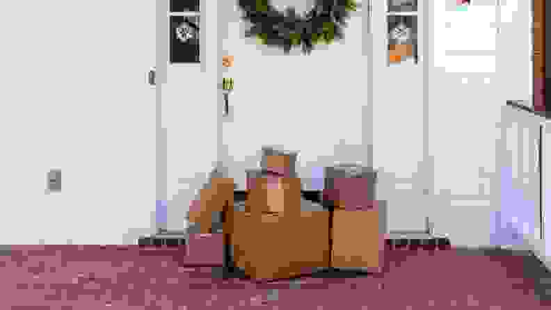 Packages stacked in front of door decorated with holiday wreath