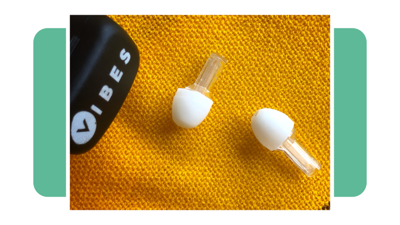Vibes earplugs next to black carrying case on top of yellow blanket.