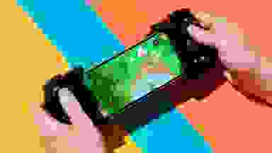 handheld controller on the sides of a phone with two hands playing it