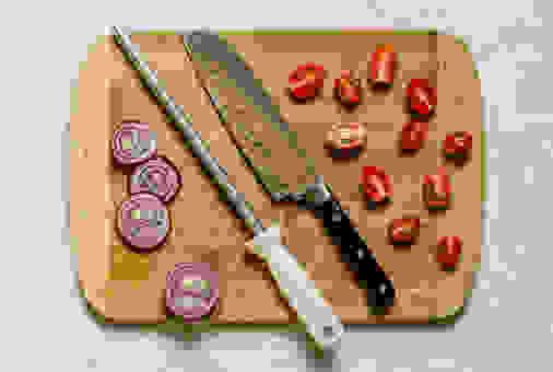 Flay lay photo of a knife sharpener (honing steel) and a chefâs knife on a cutting board