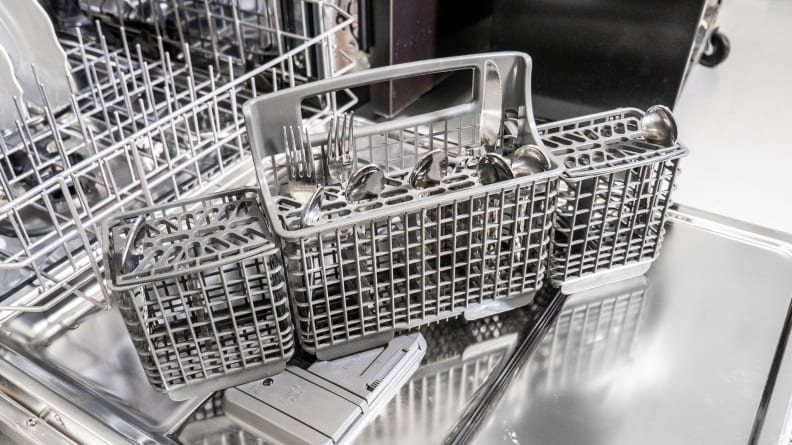 A close-up of the Whirlpool WDT750SAKZ dishwasher's cutlery basket, which has a thick plastic build. It's sitting on the open door of the Whirlpool WDT750SAKZ dishwasher.