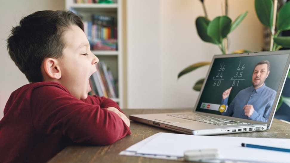 Boy yawning watching computer