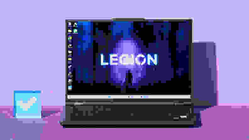 An open and powered on black laptop against a purple background