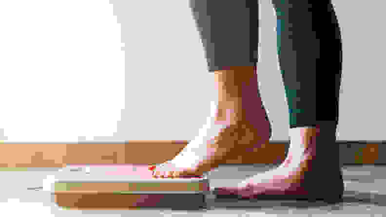 A woman stepping on the scale.