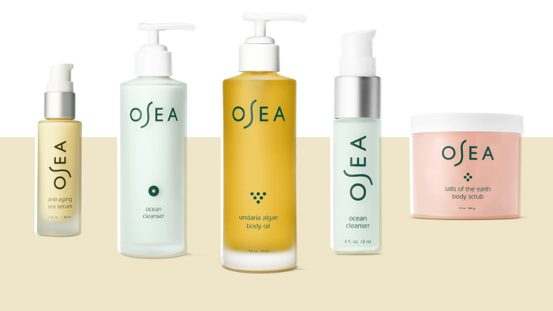 Several bottles of Osea skincare standing on a tan and white background.