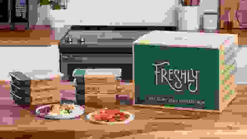 A box of Freshly pre-made meals sitting on a countertop.