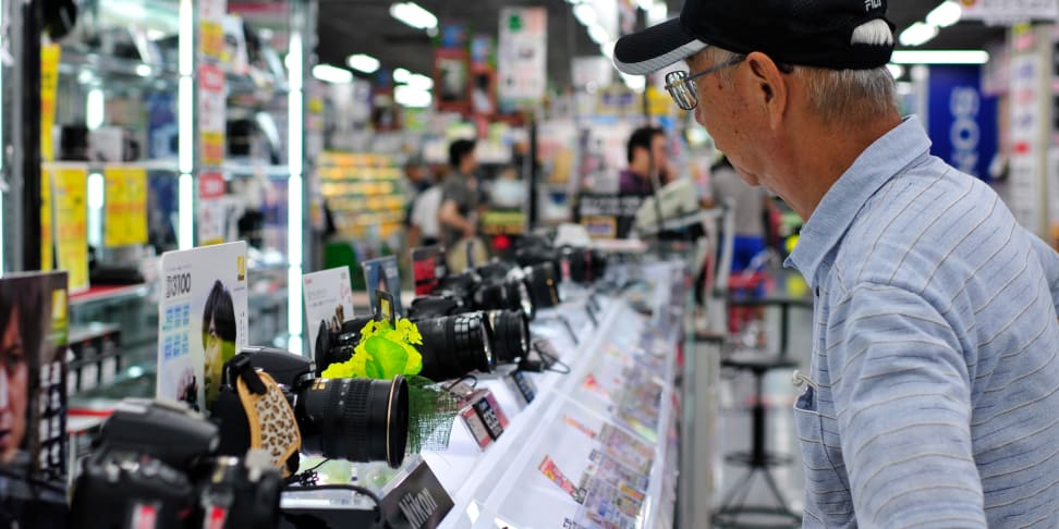 A shopper considers various lenses on display at a camera store