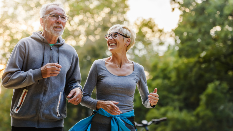 Two people smiling while walking outdoors.