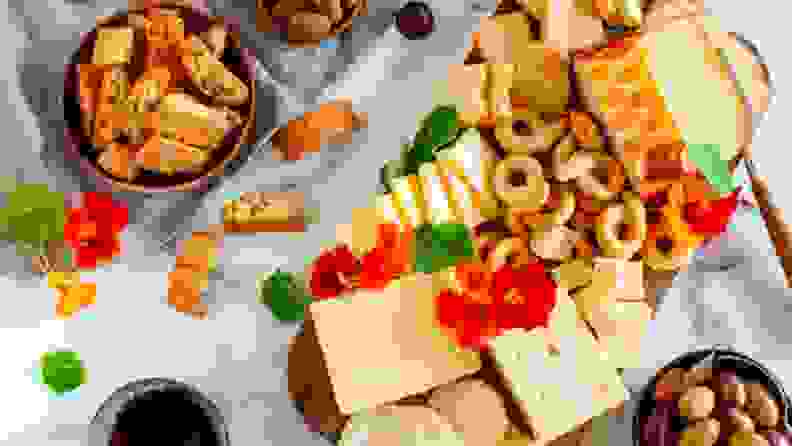 Tapas-style food, including cheeses, crackers and fruits.