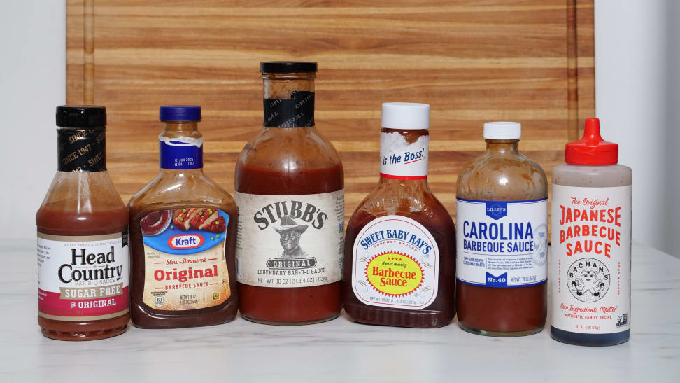 Six different bottles of BBQ sauce side-by-side.