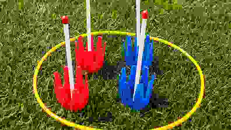 Close up of red and blue lawn darts on grass.