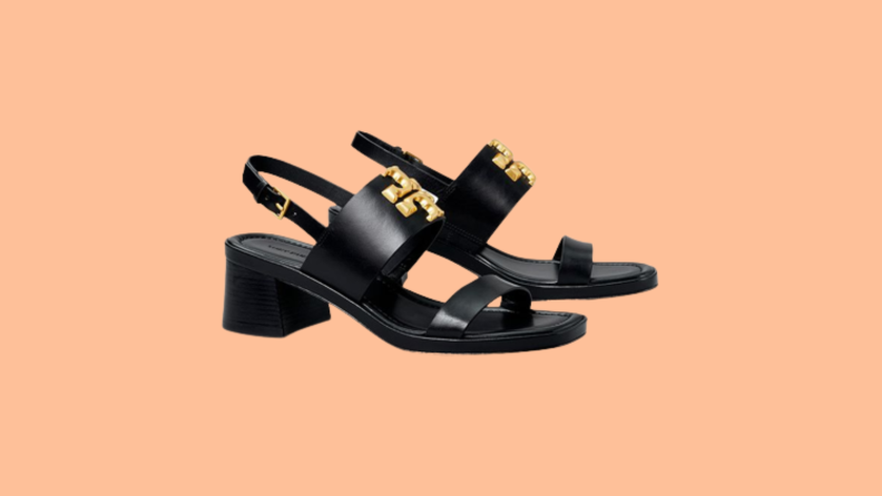 Black sandals with a block heel and a gold emblem on the strap.