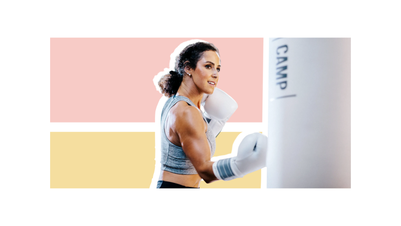 A woman wearing white boxing gloves in a fight stance against a white punching bag set against a pink and light gold background.