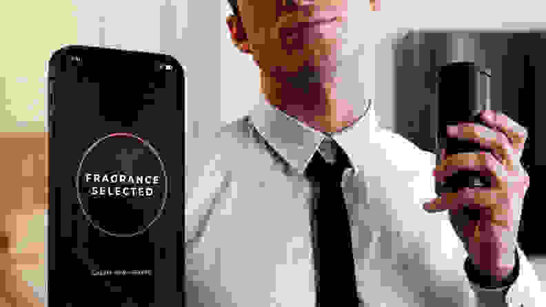 A man holding up a black canister of perfume to his neck and a smartphone screen pops up on the image to show that a perfume has been selected.