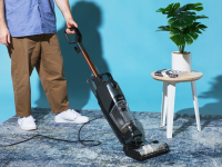 A person using Bissell CrossWave HydroSteam vacuum wet/dry vacuum on carpet.