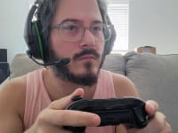Man wearing the HyperX CloudX Stinger Core while holding an Xbox controller