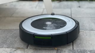 A iRobot vacuum on a stone patio