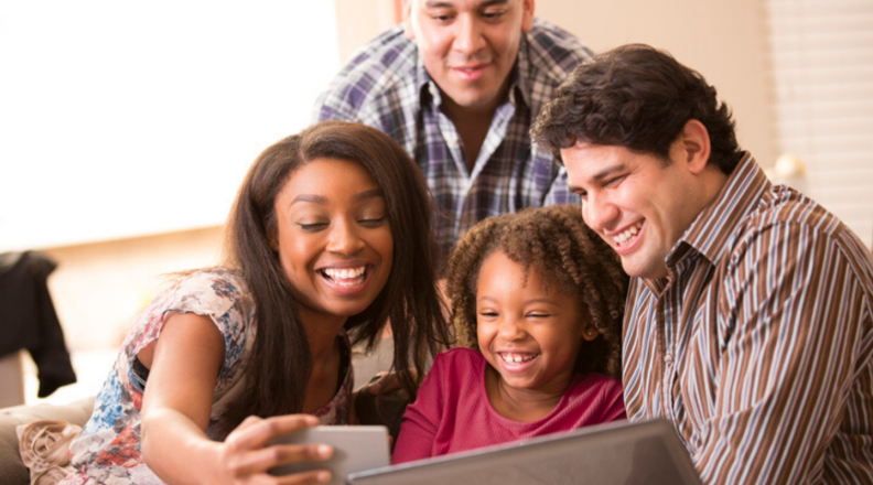 A group of four people video chat using a smartphone