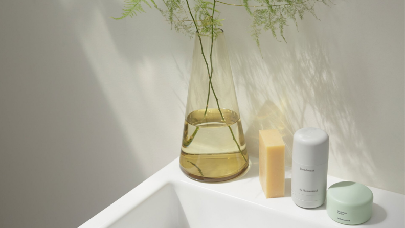 A vase of flowers and several by Humankind products sit on a countertop.