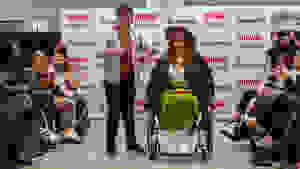 Two disabled people on runway showcasing clothes.