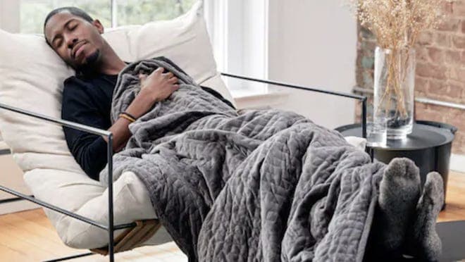 A person sleeps with a weighted Gravity blanket.