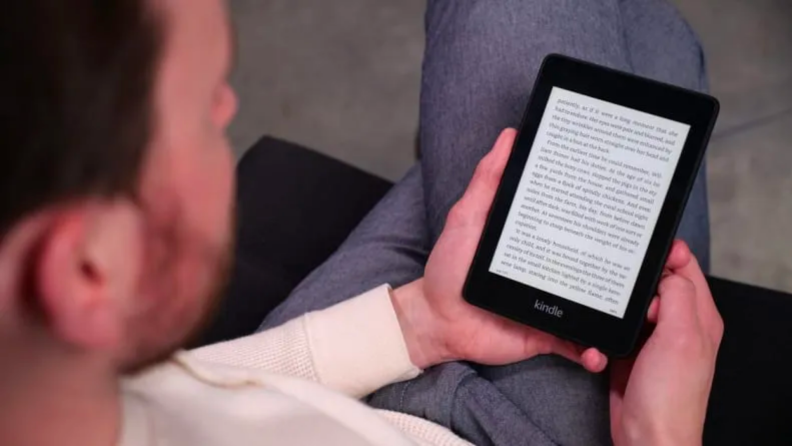 A person reads a book on an Amazon Kindle Paperwhite.