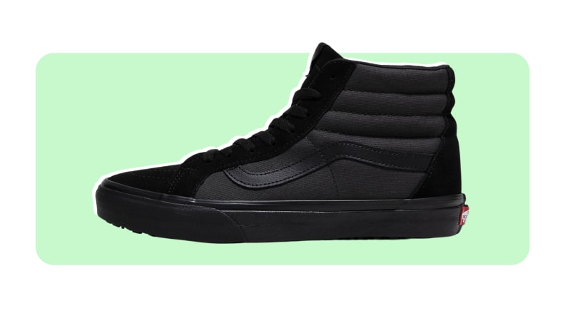 Black high-top suede Vans sneakers on a green and white background