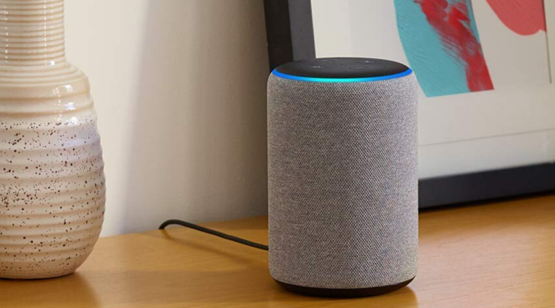 An Amazon Echo speaker sits on a table.