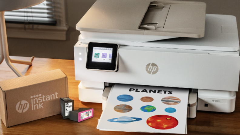 An image of an HP Printer next to a box of HP Instant Ink.