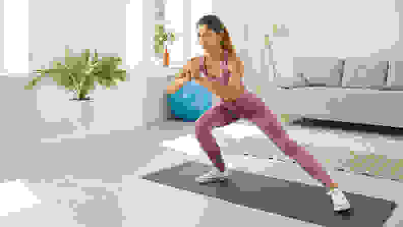 A woman doing side lunges.