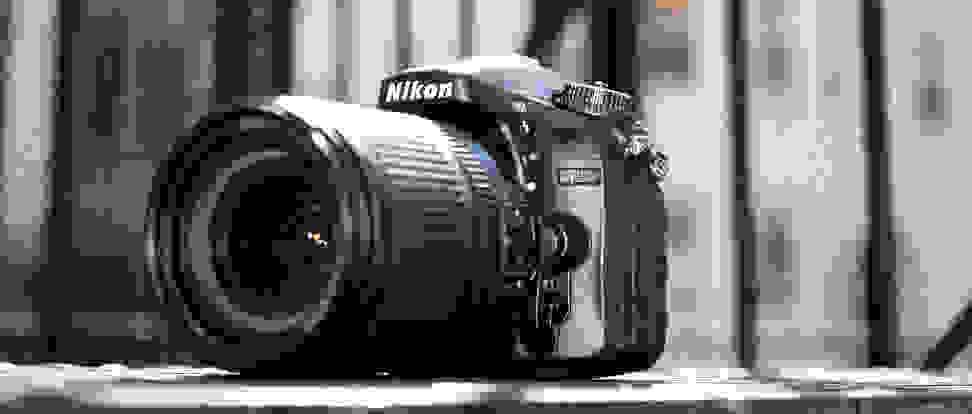 A Nikon DSLR camera with a large black lens attachment
