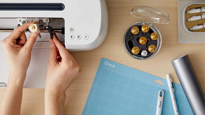 A person setting up their Cricut workspace with a tool organizer.