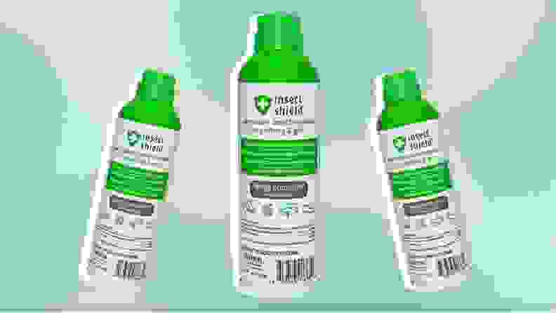 Three bottles of Insect Shield spray in front of a green background.