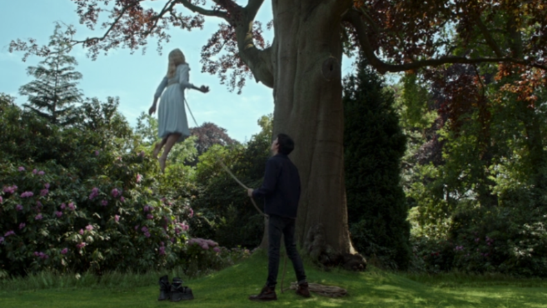 A still from 'Miss Peregrine's Home for Peculiar Children' featuring Jake holding Emma to the earth by a rope.