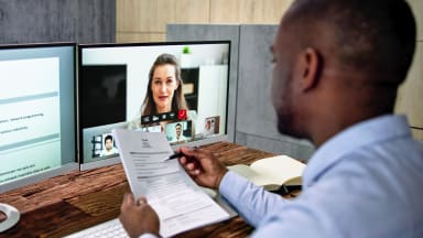 Man holding his resume doing a virtual job interview
