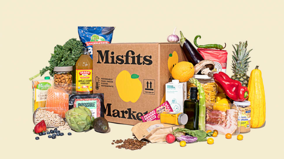 Misfits Market box surrounded by a variety of produce and grocery items.