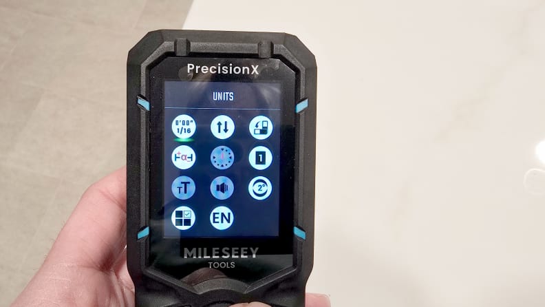 A hand holds a laser level