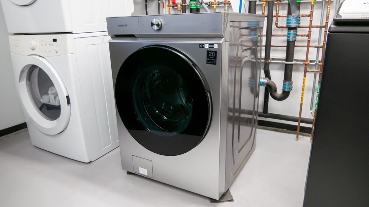 Product shot of the stainless steel Samsung Bespoke WF53BB8700AT front-load washer machine inside inside of testing lab.