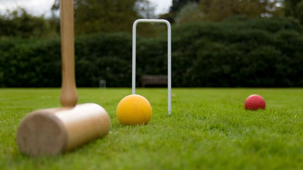 草地上的槌球槌、球和三柱门