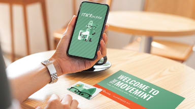 Person holding smartphone displaying Mint Mobile on screen