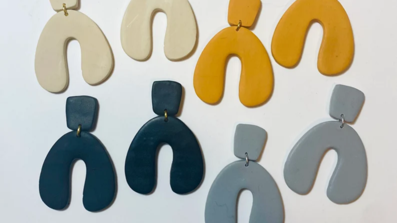 An image of the same style of polymer clay earrings in gold, white, blue, and gray.