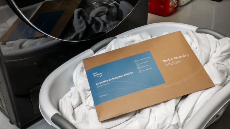 A cardboard sleeve of Hey Sunday laundry detergent sheets in a basket.
