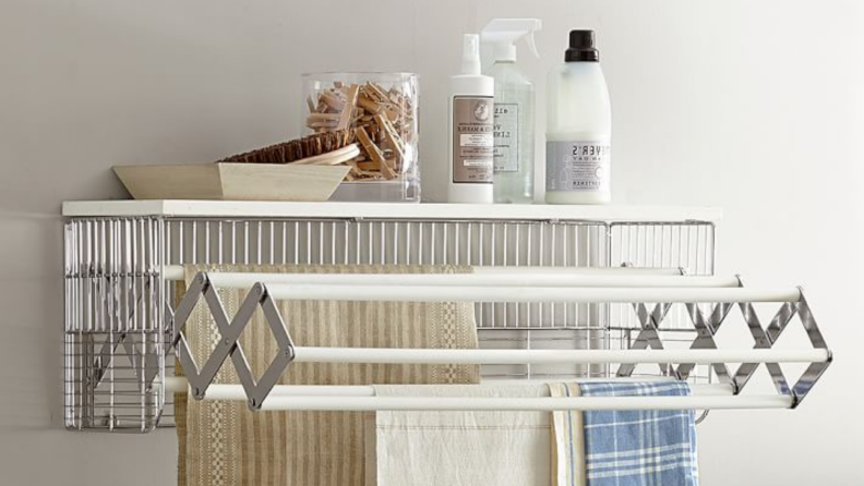 Pottery Barn's collapsible drying rack provides extra storage space for spray bottles, clothespins, and other necessities.