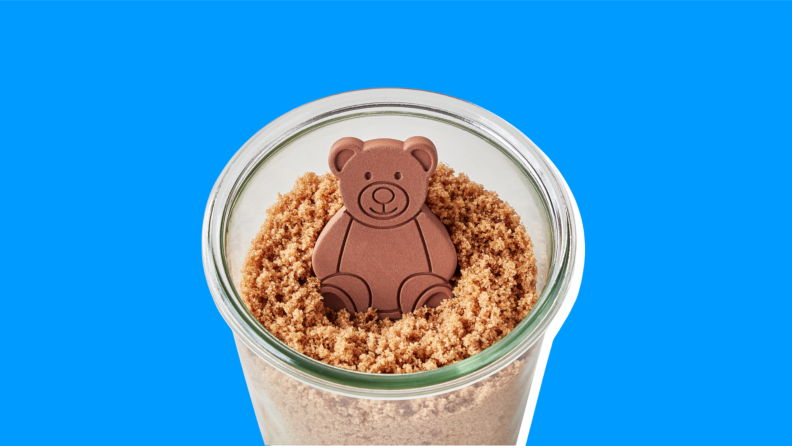 A Brown Sugar Bear inside a cup with food in it on a blue background.