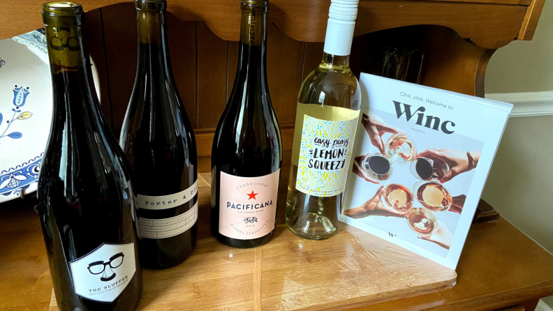 Four bottles of wine on a wooden surface.