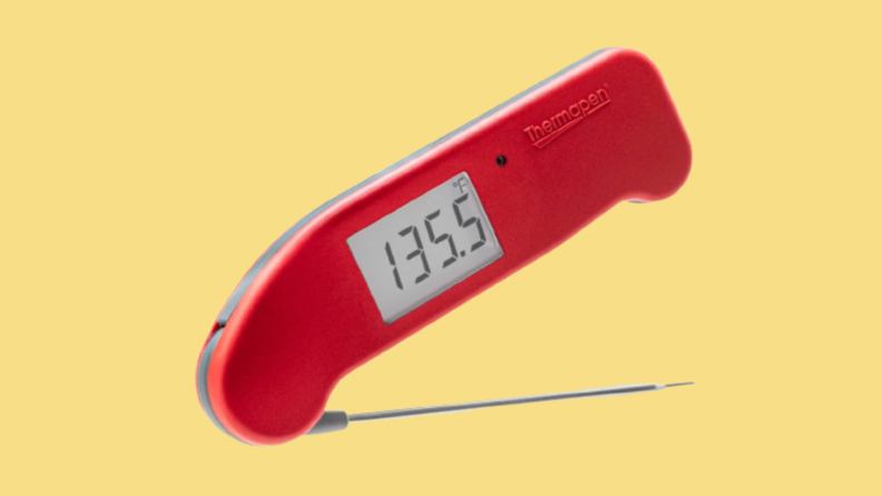 Red meat thermometer against yellow background