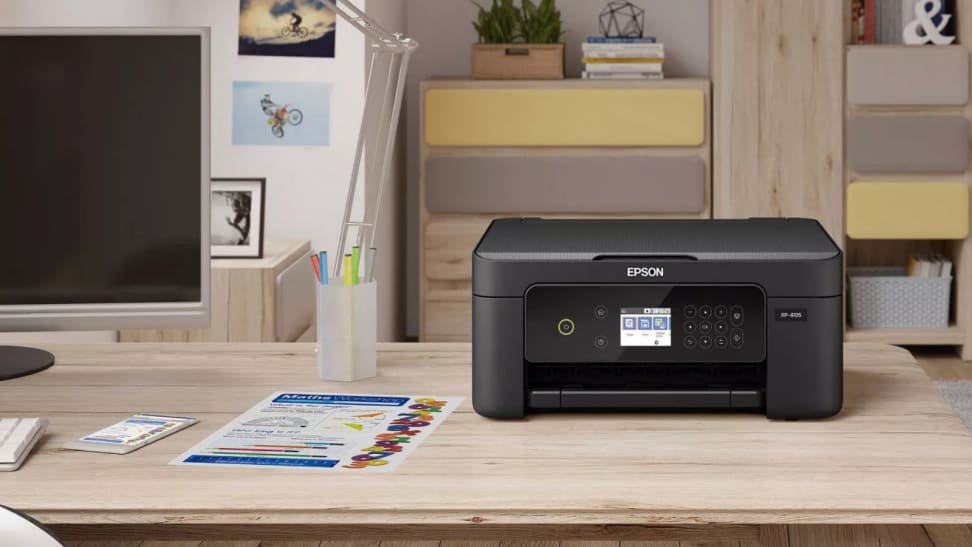 An image of an Epson printer sitting on a desk alongside a computer monitor.