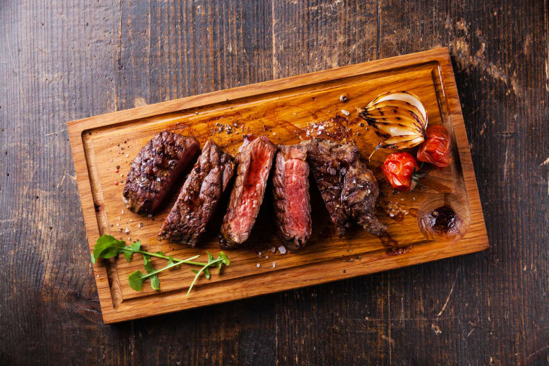Sliced steak resting on a wooden cutting board